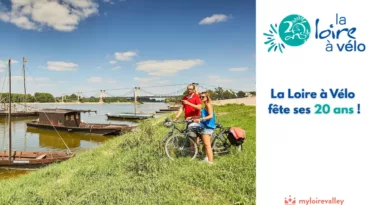 photo d'un couple de cyclistes en bord de Loire l'été avec des bateaux en bois
