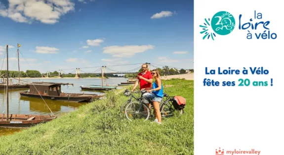 photo d'un couple de cyclistes en bord de Loire l'été avec des bateaux en bois