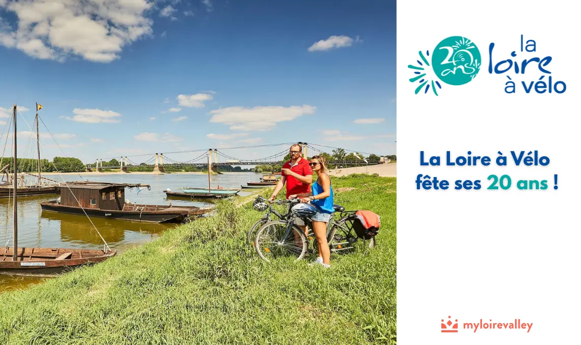 photo d'un couple de cyclistes en bord de Loire l'été avec des bateaux en bois